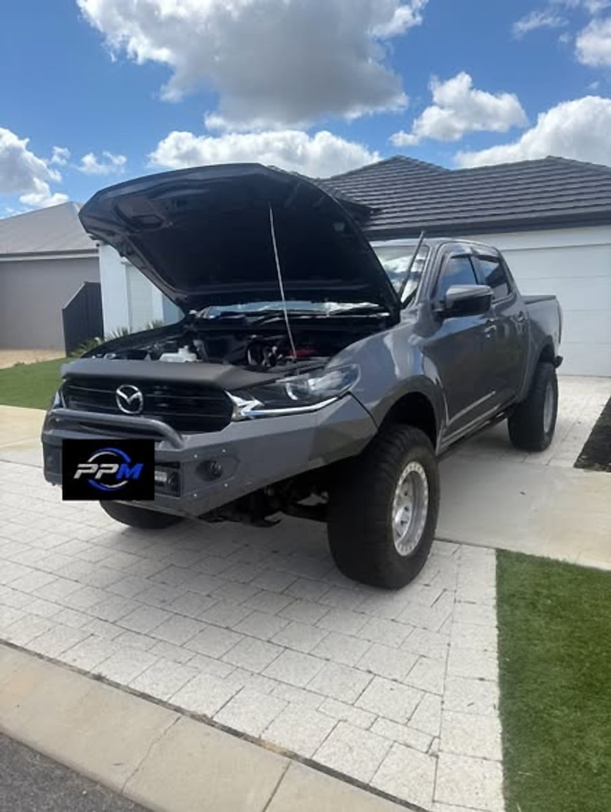 Grey Mazda BT-50 with the bonnet raised in a driveway