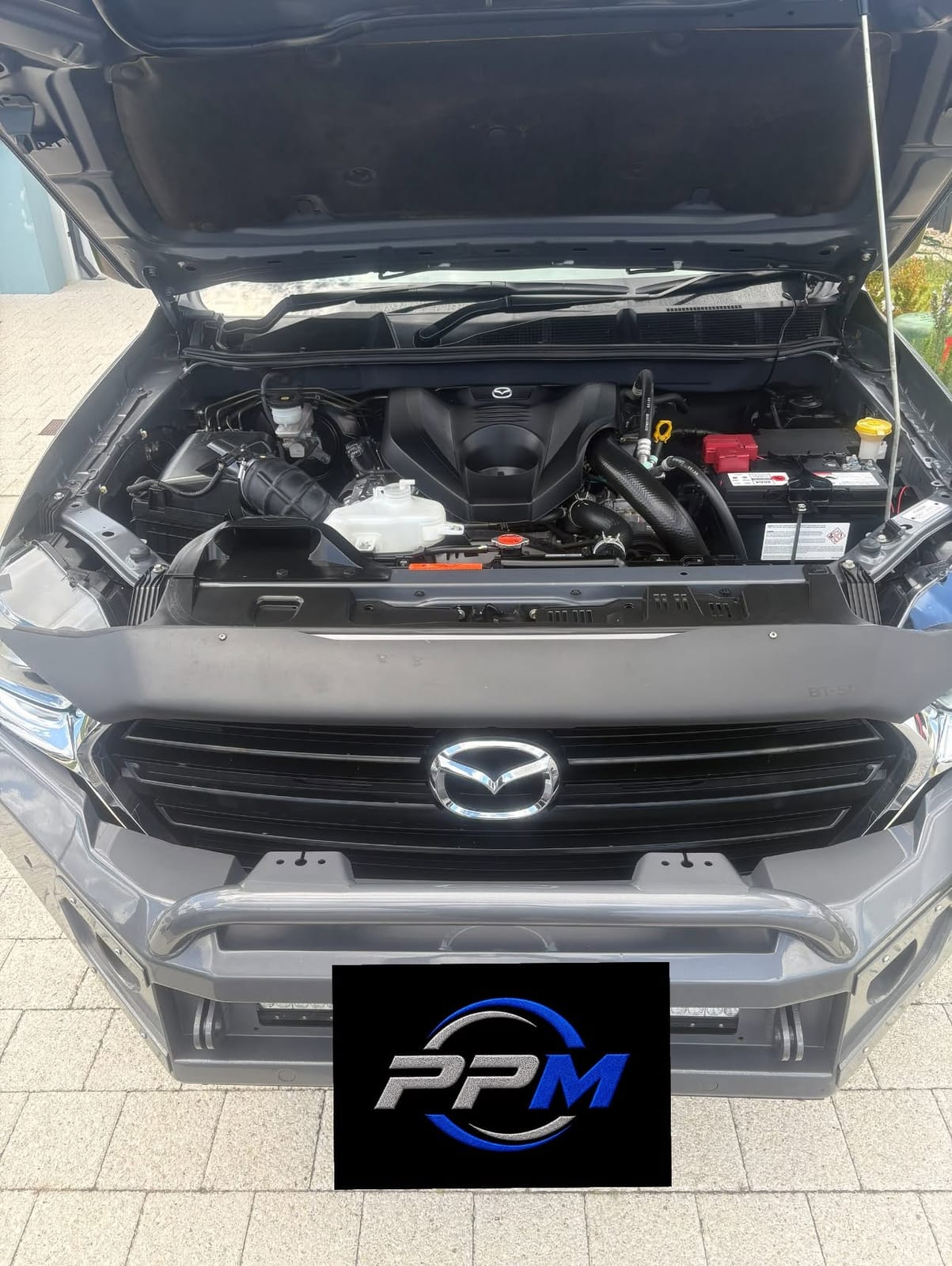Mazda BT-50 with its bonnet open on a Perth driveway during a service, with the Peak Performance plate on the bull bar