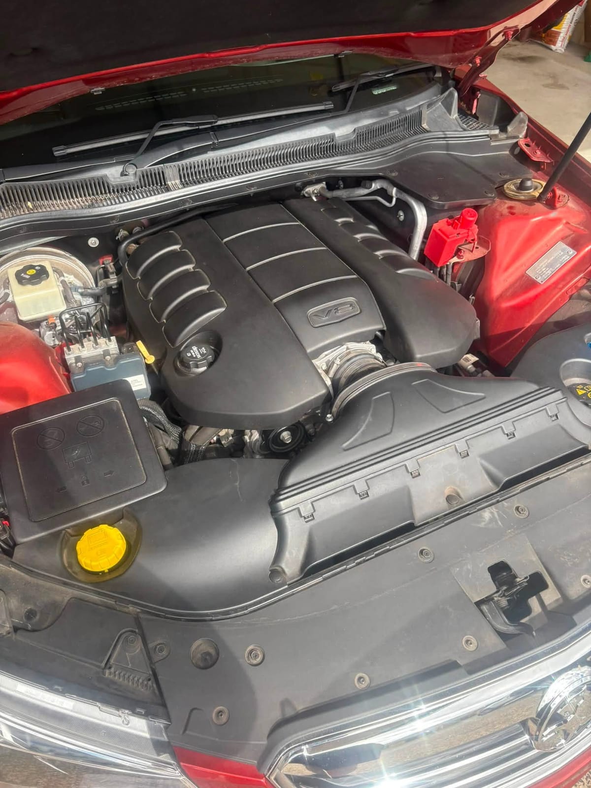 Engine bay of a red Holden VF Commodore Calais V8 with the bonnet open