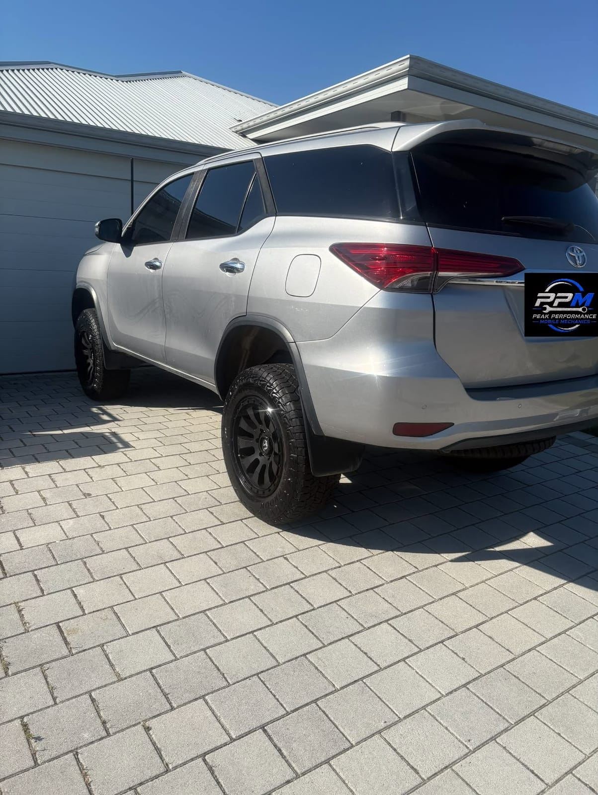 Silver Toyota Fortuner on paving in front of a house