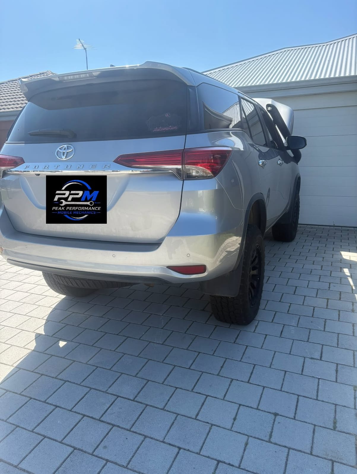Rear of the silver Fortuner with the Peak Performance plate