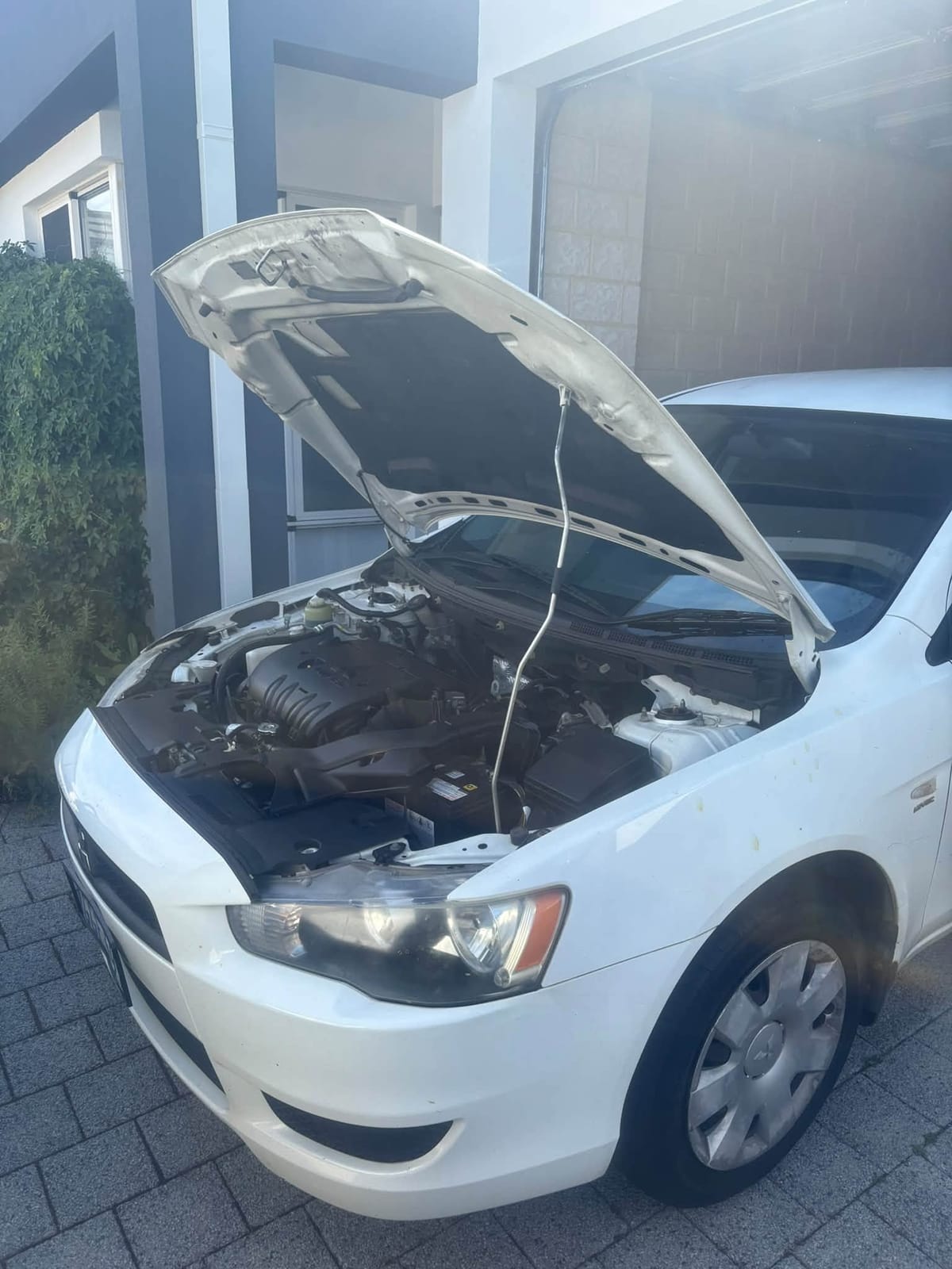 White Lancer with the bonnet propped open during the service
