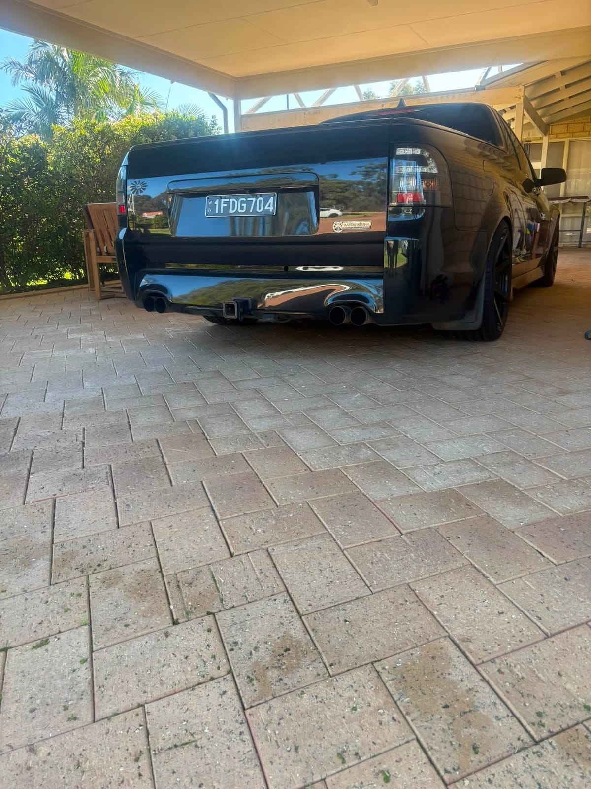 Black VE SSV Commodore from the rear, showing its quad exhaust tips and number plate